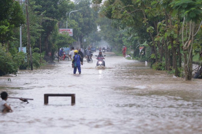 BANJIR: Ruas jalan dan permukiman di wilayah Kecamatan Madiun tergenang akibat hujan deras semalam suntuk kemarin (22/3). (BAGUS RAHADI/JAWA POS RADAR MADIUN)