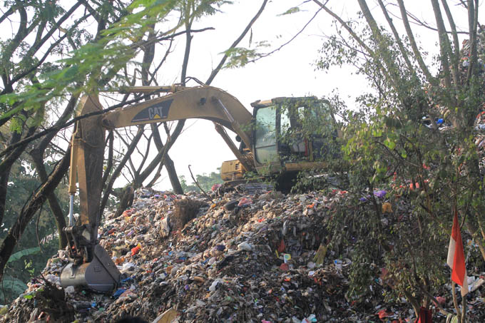 LIMBAH: Alat berat hasil pinjaman DLH Ponorogo dikerhakan untuk mengelola penumpukan sampah di TPA Mrican. (AJI PUTRA/RADAR PONOROGO)
