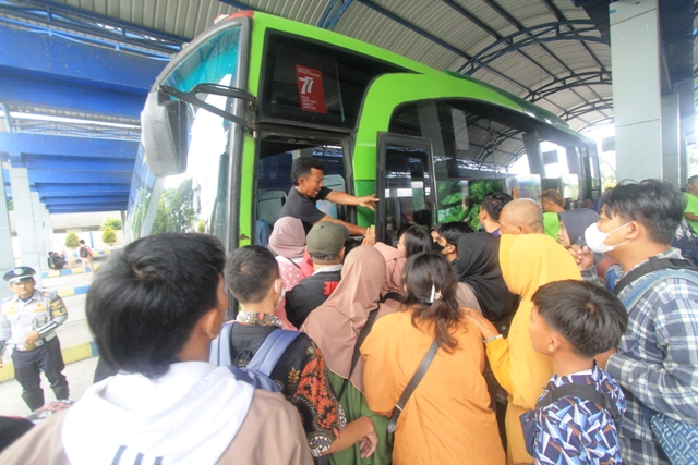 ARUS BALIK: Puluhan penumpang berebut menaiki bus yang baru datang di pos pemberangkatan Terminal Tipe A Seloaji Ponorogo kemarin (26/4). (AJI PUTRA/JAWA POS RADAR PONOROGO)
