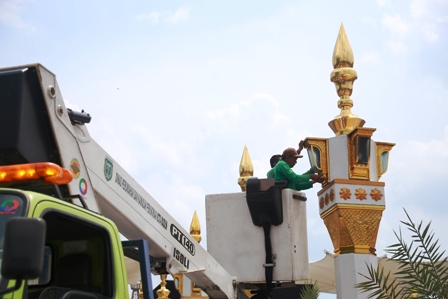 PEMELIHARAAN: Petugas Disperkim Kota Madiun memperbaiki lampu PJU yang rusak. (BAGAS BIMANTARA/JAWA POS RADAR MADIUN)