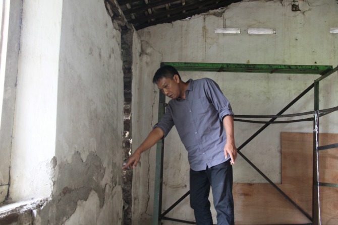 RUSAK PARAH: Anggota tim teknis Bapelbud Wilayah XI Jawa Timur mengamati dinding ruang bangunan bekas Kawasan Kepatihan yang retak kemarin. (ASEP SYAEFUL BACHRI/JAWA POS RADAR NGAWI)