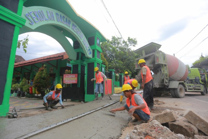 REHAB FASUM: Sejumlah pekerja proyek revitalisasi trotoar pedestrian di kawasan Masjid Kuno Kuncen tengah beraktivitas, Selasa (11/4). (BAGAS BIMANTARA/JAWA POS RADAR MADIUN)