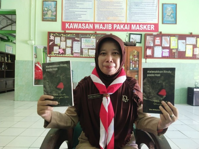 PRODUKTIF: Dian Widyawati menunjukkan buku kumpulan puisi berjudul Meletakkan Cinta pada Hati. (RAHMA DWI LESTARI/JAWA POS RADAR MADIUN)
