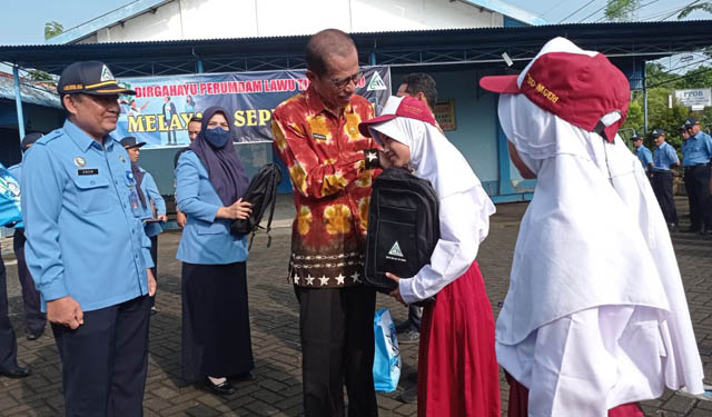 SIMBOLIS : Bupati Magetan Suprawoto didampingi Dirut Perumdam Lawu Tirta Moh. Choirul Anam menyerahkan bantuan kepada siswi SDN Genilangit 2. (ERIC WIBOWO/RADAR MAGETAN)