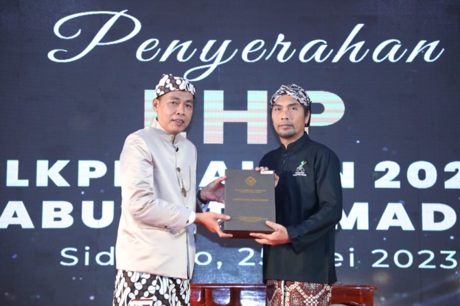 PRESTISIUS: Bupati Madiun Ahmad Dawami saat menerima LHP dari Kepala BPK RI Perwakilan Jawa Timur Karyadi di Sidoarjo kemarin. (DISKOMINFO UNTUK RADAR CARUBAN)