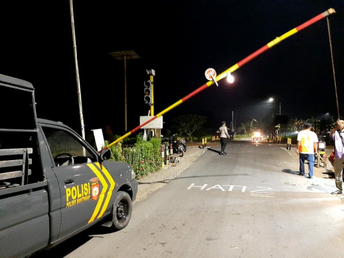 PALANG DARI BAMBU: Anggota Polsek Mantingan melakukan patroli malam di perlintasan kereta api sebidang Desa Pakah, Mantingan. (ISTIMEWA)