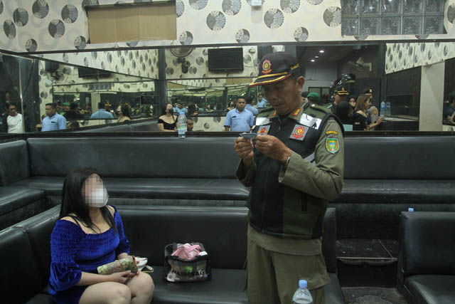 RAZIA: Petugas gabungan dari Satpol PP, TNI/Polri melakukan pemeriksaan identitas para LC di sejumlah tempat karaoke dan hiburan malam di Kota Madiun pada, Senin (22/5) malam lalu. (BAGAS BIMANTARA/JAWA POS RADAR MADIUN)