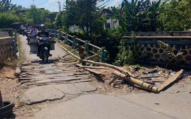 MEMBAHAYAKAN: Jembatan Klumutan masih dilalui pengendara roda dua meski kondisinya semakin ambles. (LODITYA FERNANDEZ/RADAR MADIUN)