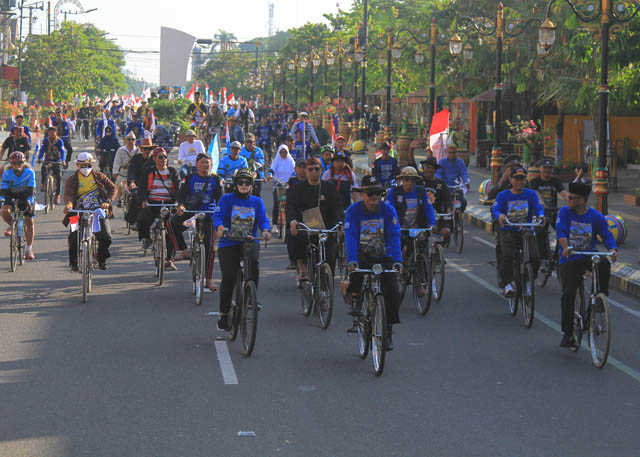 SEMARAK : Pelaksanan Munas Kosti 2023 di Kota Madiun diikuti ribuan pehobi sepeda dari sejumlah daerah. Wali Kota Madiun Maidi tampak berada di barisan depan mengendarai sepeda kebo milikya. (BAGAS BIMANTARA/JAWA POS RADAR MADIUN