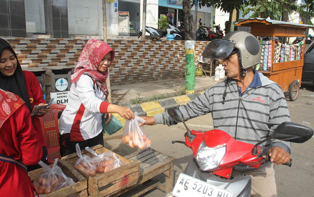 MAHAL: Operasi pasar dilakukan oleh Dinas Perdagangan dan PPI Cabang Madiun di PBM untuk menekan harga telur ayam ras yang terus merangkak naik kemarin (19/5). (BAGAS BIMANTARA/JAWA POS RADAR MADIUN)