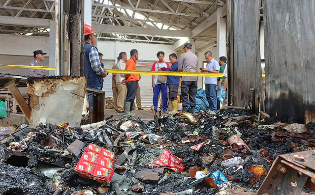 SISA KEBAKARAN : Petugas Labfor Polda Jatim tengah menggali keterangan sejumlah saksi yang mengetahui kebakaran Pasar Arjosari, kemarin (29/5). (NUR CAHYONO/JAWA POS RADAR PACITAN)