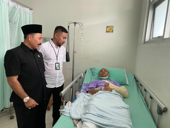 CEKATAN: Kepala BPJS Ketenagakerjaan Cabang Ponorogo Wawan Bahrudin dan Ketua Cabang PSHT Ponorogo Moh. Komarudin menjenguk atlet yang mengalami kecelakaan saat latihan. (ISTIMEWA)