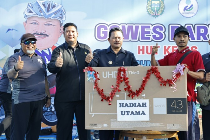 DOORPRIZE: Wali Kota Madiun Maidi (dua dari kanan) memberikan hadiah utama kepada pemenang undian gowes (kanan) saat peringatan HUT ke-46 PDAM Tirta Taman Sari, Selasa (23/5). Maidi ditemani Dirut PDAM Tirta Taman Sari Suyoto (kiri) dan Ketua DPRD Andi Ra