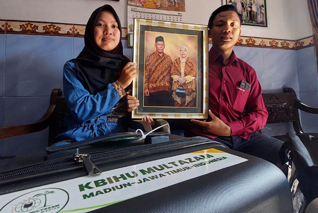 ADIK-KAKAK: Fiki dan Shoim menunjukkan foto mendiang kedua orang tuanya. (DIAN RAHAYU/JAWA POS RADAR CARUBAN)