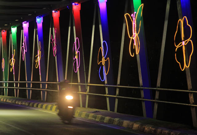INDAH: Jembatan Branjangan dipasangi lampu hias warna-warni berbentuk kupu-kupu dan bunga. (BAGAS BIMANTARA/JAWA POS RADAR MADIUN)