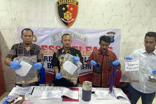 Kasat Reskrim Polresta Banjarmasin Kompol Thomas Afrian (kedua kiri) menunjukkan barang bukti satu kilogram emas di Polresta Banjarmasin, Kalimantan Selatan, Jumat (19/5). (Tumpal Andani Aritonang/Antara)