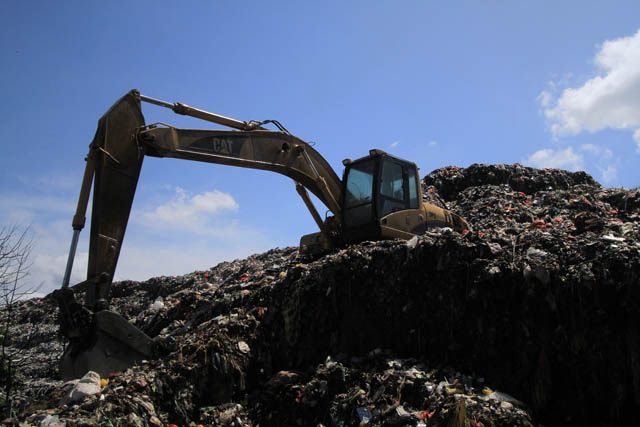OVERLOAD: Satu unit alat berat milik DLH dikerahkan untuk meratakan tumpukan sampah yang berada di TPA Mrican. (AJI PUTRA/RADAR PONOROGO)
