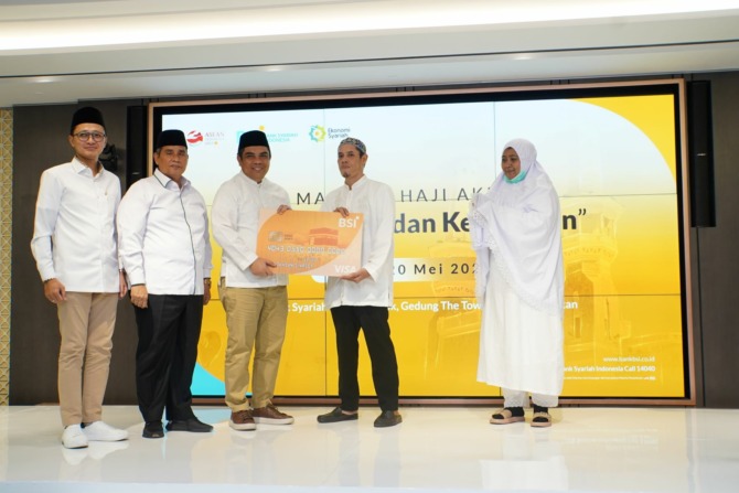 DUKUNGAN: Direktur Sales & Distribution BSI Anton Sukarna (tengah) menyerahkan Kartu Debit Haji Indonesia kepada salah satu CJH, didampingi Dirjen PHU Kemenag Jaja Jaelani (dua dari kiri) dan SVP Islamic Ecosystem BSI M. Syukron Habiby (paling kiri). (BSI
