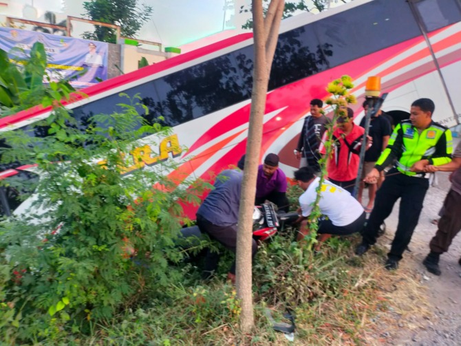 EVAKUASI: Petugas berusaha menarik motor Supra X dan bus Mira yang terperosok di tepian jembatan kembar, Jalan Raya Ngawi-Maospati masuk Desa Tambakromo, Geneng, kemarin. (SATLANTAS UNTUK RADAR NGAWI)