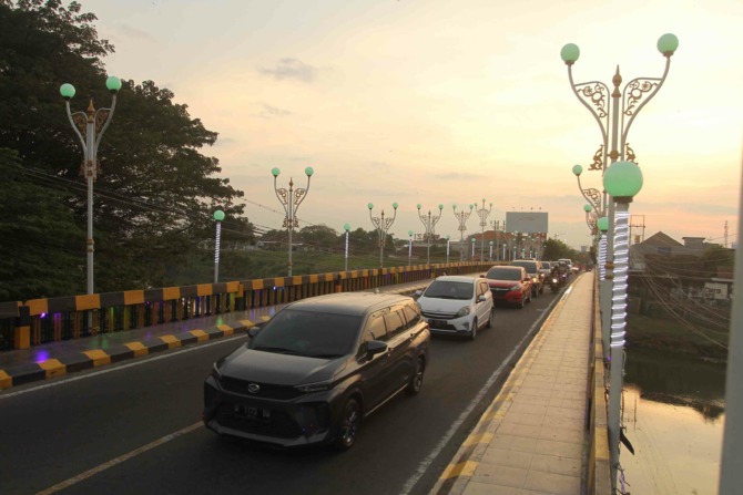 PADAT MERAYAP: Antrean kendaraan yang ingin masuk ke Kota Madiun di Jembatan Manguharjo kemarin (2/6). (BAGAS BIMANTARA/JAWA POS RADAR MADIUN)