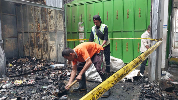 BERSIHKAN PUING: Perbaikan kios terdampak kebakaran di Pasar Arjosari baru akan dilakukan akhir tahun nanti. (DOKUMENTASI/JAWA POS RADAR PACITAN)