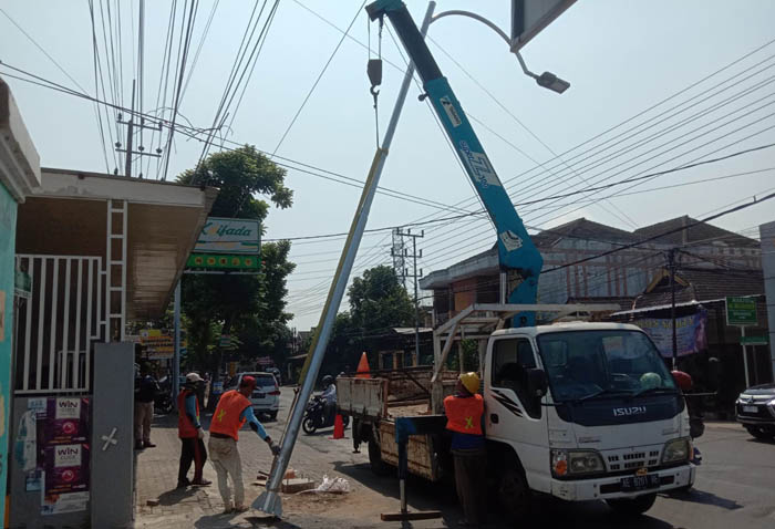 TERANG BENDERANG: Petugas dari disperkim memasang 264 lampu PJU anyar di empat ruas jalan di Kota Madiun. (DISPERKIM FOR JAWA POS RADAR MADIUN)