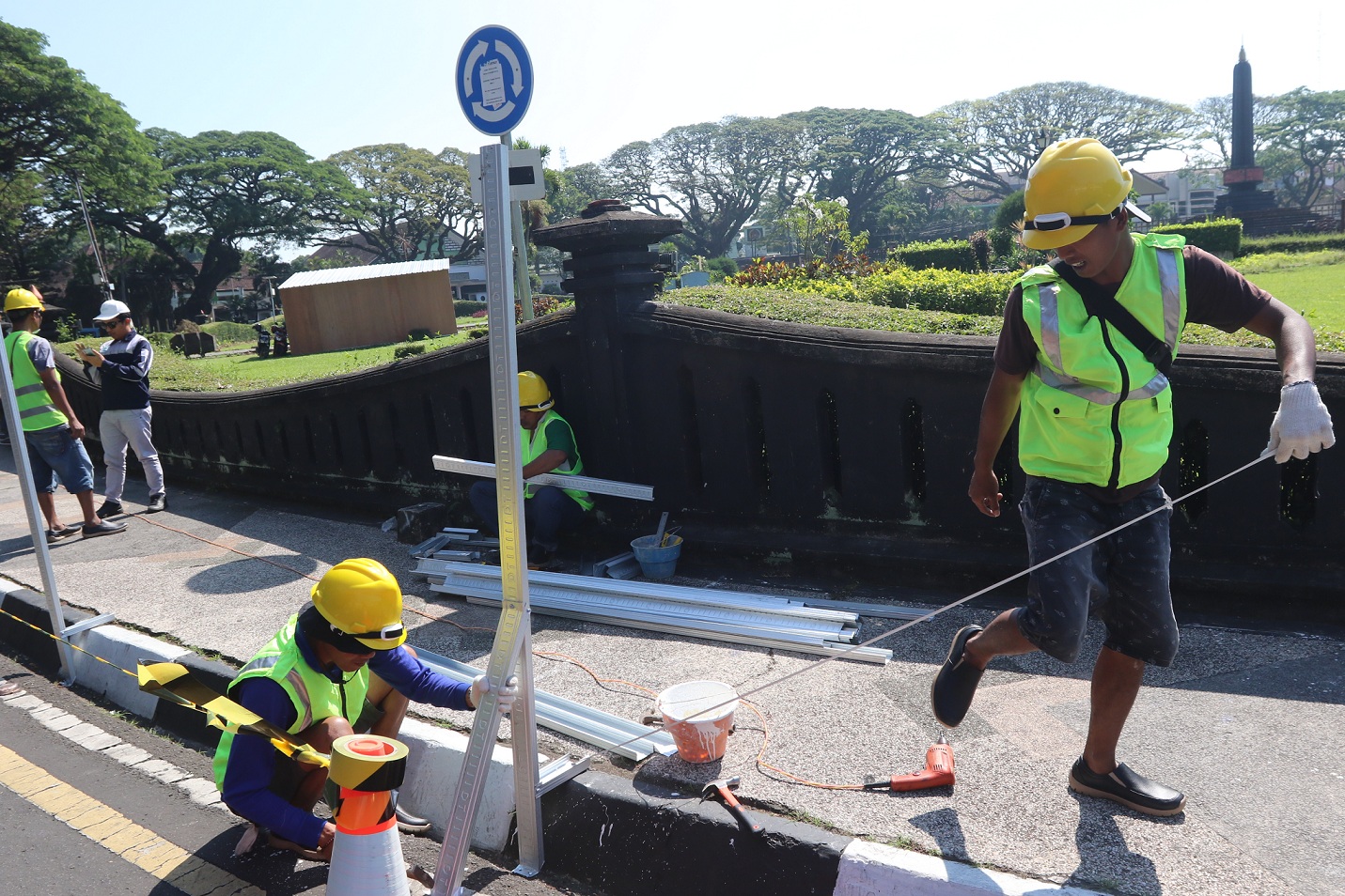 TANDA PROYEK DIMULAI: Sejumlah pekerja memasang tiang penutup proyek revitalisasi Alun-Alun Tugu, kemarin siang. (darmono/radar malang)