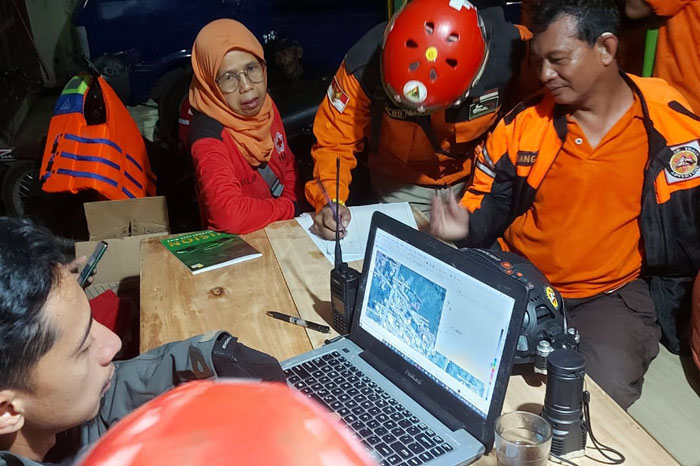 Relawan dan tim SAR berkoordinasi di posko penyelamatan setelah sempat melakukan penyisiran tepi Sungai Brantas di RT 6/RW 5, Kelurahan Bumiayu, Kecamatan Bumiayu, tadi malam (19/6), pukul 20.00.