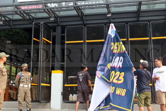 IZIN BELUM BERES: Banner pemberitahuan jadwal grand opening Mie Gacoan Sawojajar dicopot setelah perwakilan Pemkot Malang datang ke sana, kemarin.
