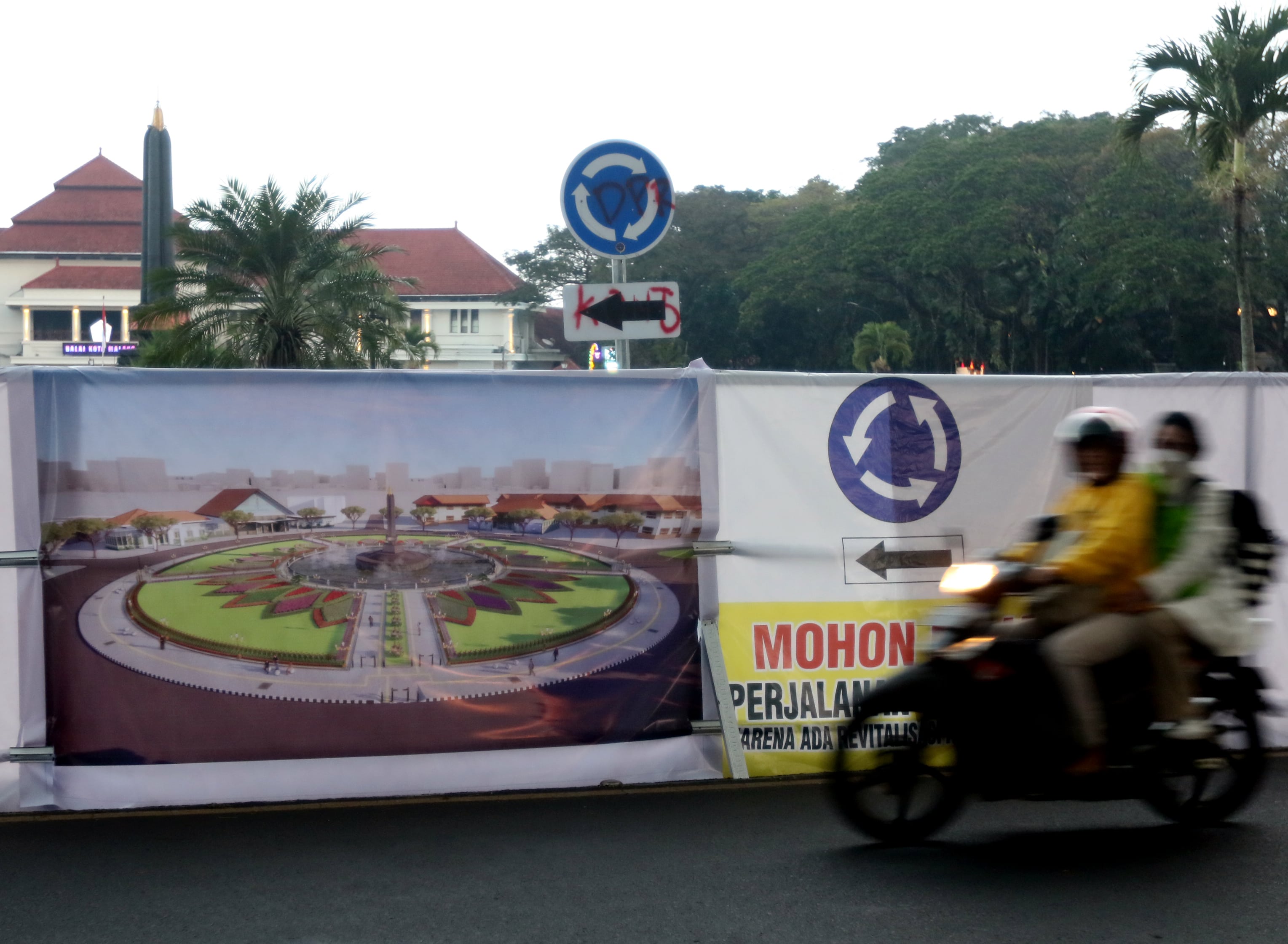 WAJAH BARU: Pengendara melintasi banner bergambar desain Alun-Alun Tugu setelah direvitalisasi.