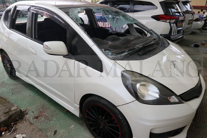 Mobil Honda Jazz turut dirusak gerombolan dalam kericuhan di Tegalgondo belakang Universitas Muhammadiyah Malang.