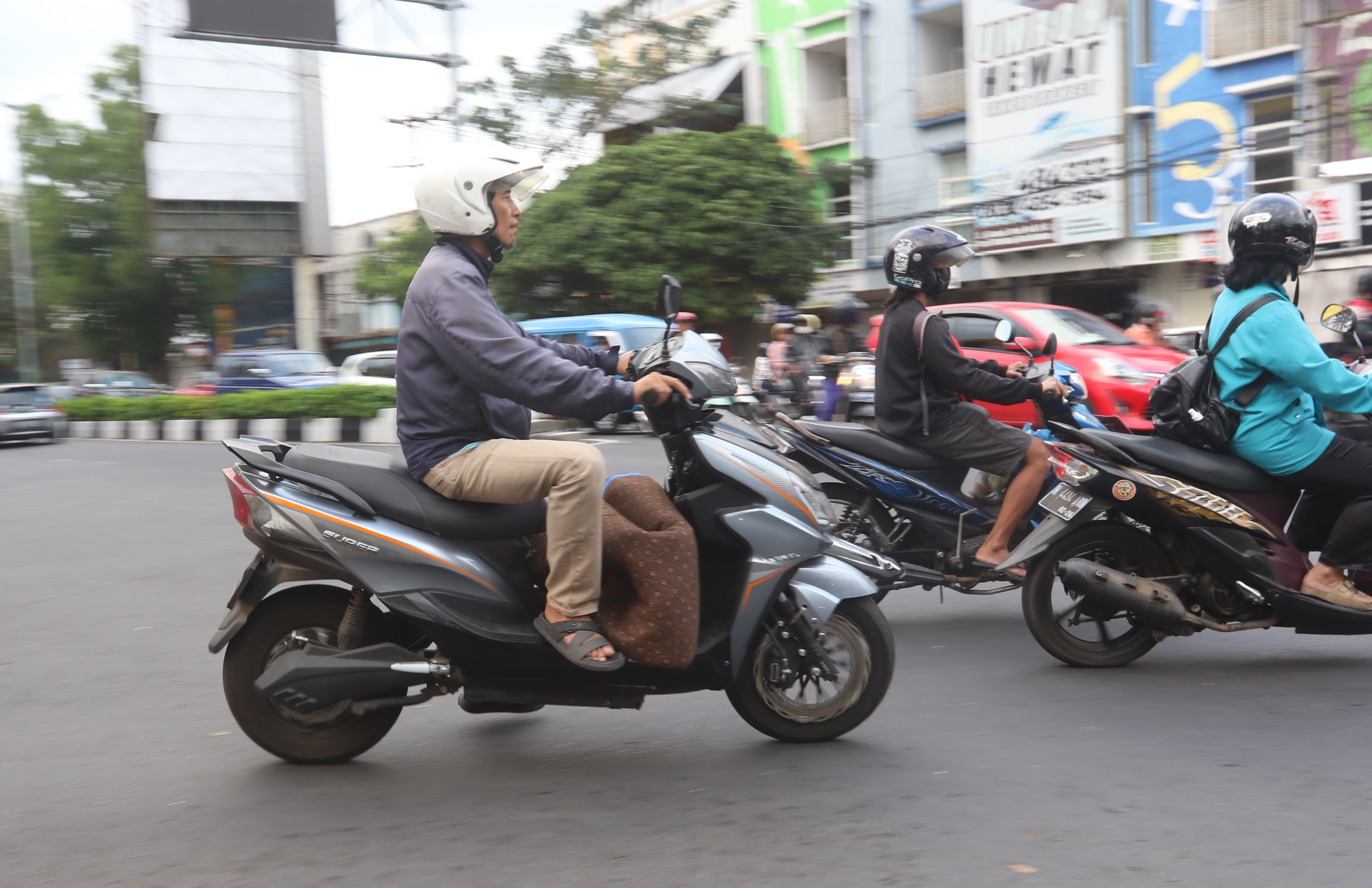 RAMAH LINGKUNGAN: Pengendara motor listrik mengaspal di jalan raya Kota Malang, Jumat lalu (30/6).