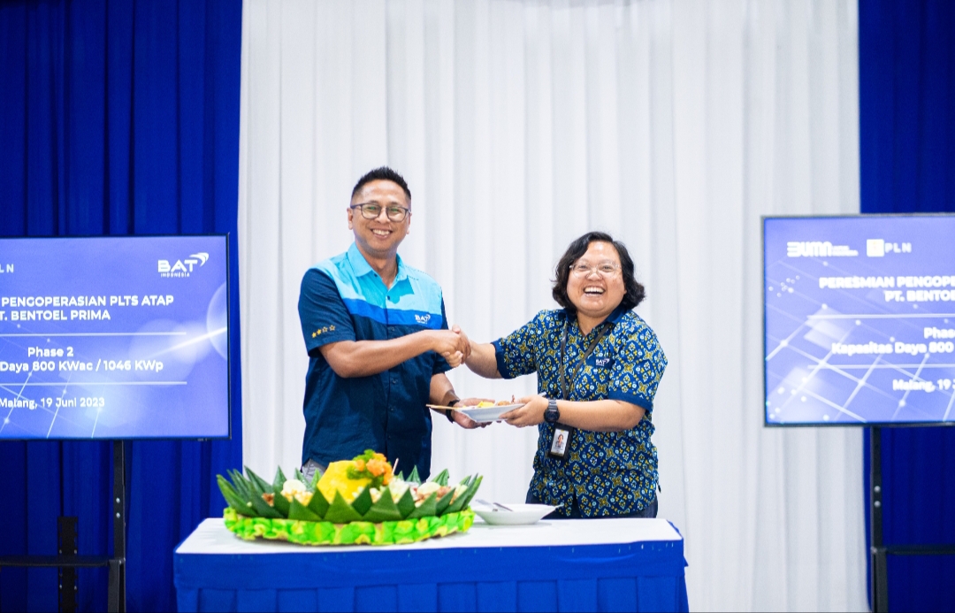 Head of Ops Regulatory External Affairs Bentoel Group Latifu Shabur menerima potongan tumpeng dari Area Sustainability Manager Evi Sulistyawati