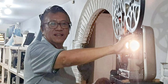 Hariadi memutar film menggunakan proyektor lawas di rumahnya, Jalan BS. Riyadi, Kelurahan Oro-Oro Dowo, kemarin.