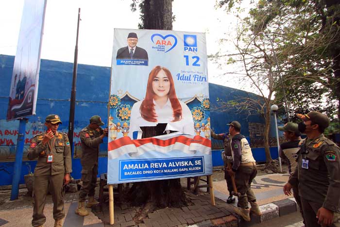 Penertiban reklame dilakukan petugas di Jalan Kawi, kemarin siang. Tujuh titik lainnya juga disasar petugas dari Satpol PP.