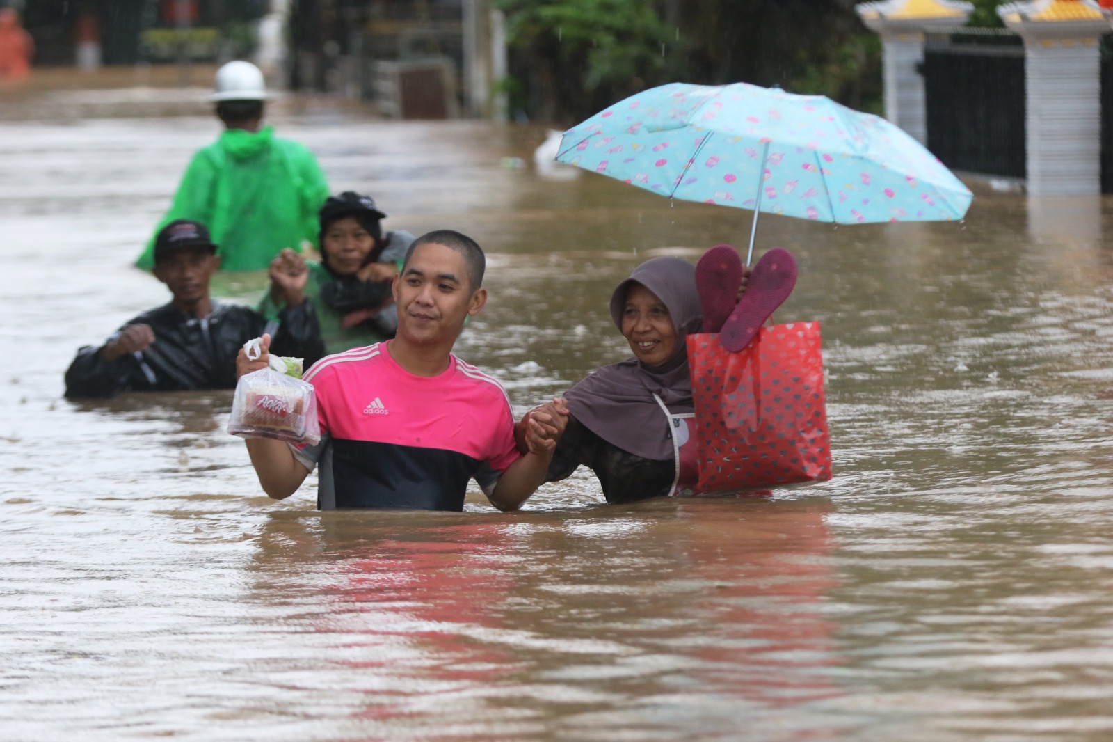 Warga Sitiarjo menembus genangan banjir sedada, kemarin.