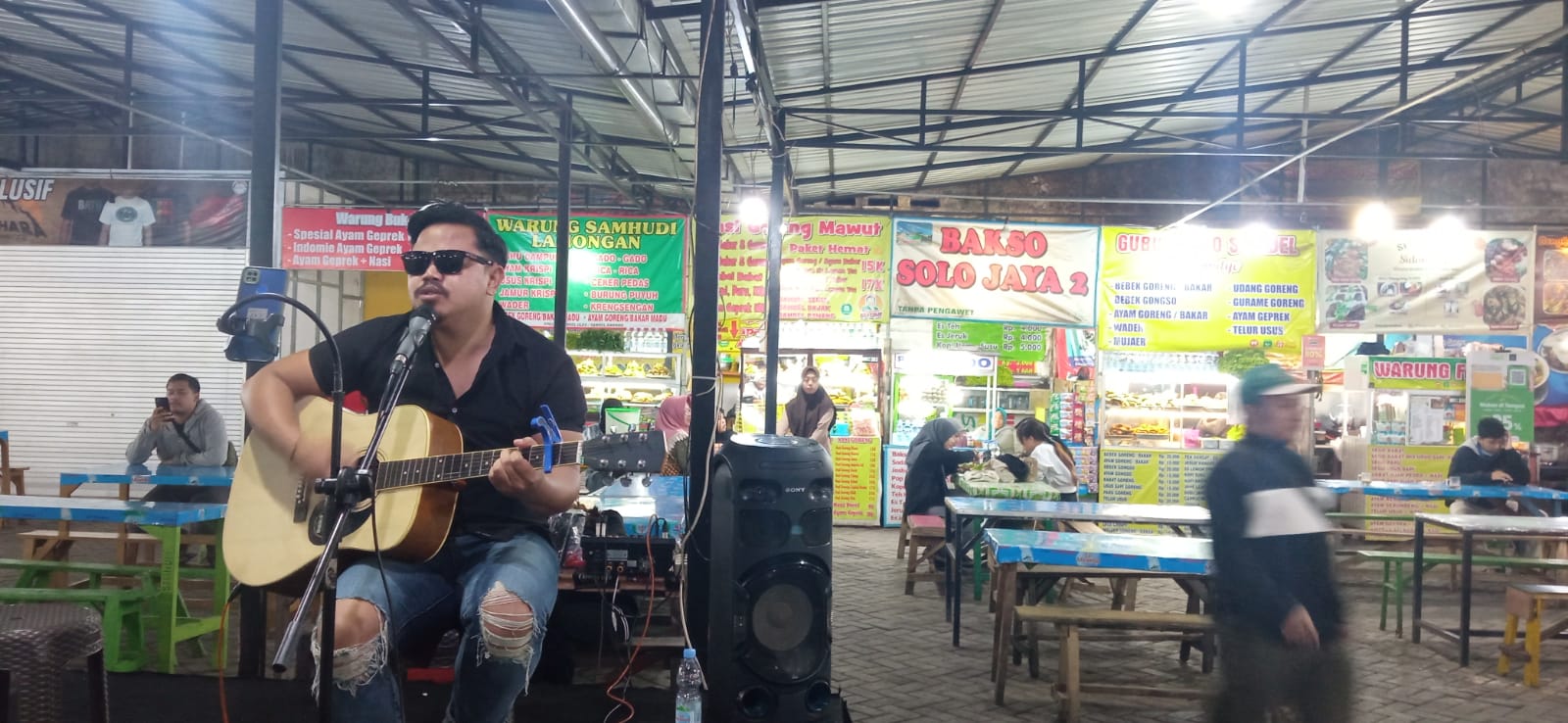 TARIK PENGUNJUNG: Pasar Panggung Alun-Alun Kota Batu menyajikan live music untuk menggaet pelanggan, kemarin.