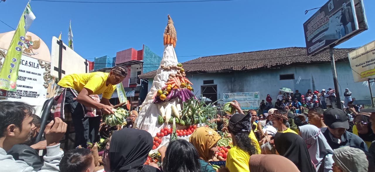 REBUTAN: Warga Desa Oro-Oro Ombo rebutan tumpeng buah yang diarak dalam acara pawai budaya untuk memeriahkan Hari Ulang Tahun Ke-110 desa tersebut, Rabu (12/7).