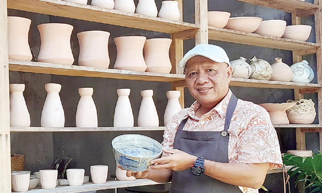 Muchlis Arif Sutopo bersama deretan keramik karyanya di Studio Matahati Ceramics, Jalan Wastu Asri, Kecamatan Junrejo, Kota Batu.