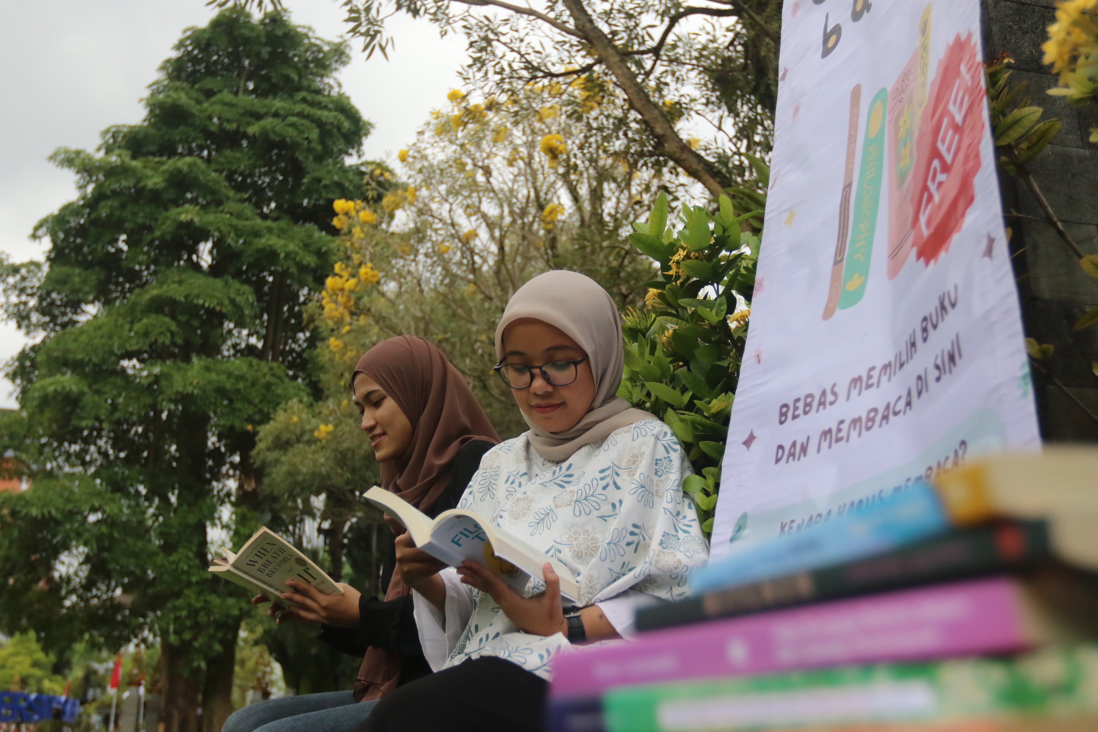 AJAK MEMBACA: Triyana Sinta Dewi (kiri) dan Farah Sajidah, dua pelopor Komunitas Duduk Baca saat di Alun-Alun Kota Malang, Minggu lalu (9/7).