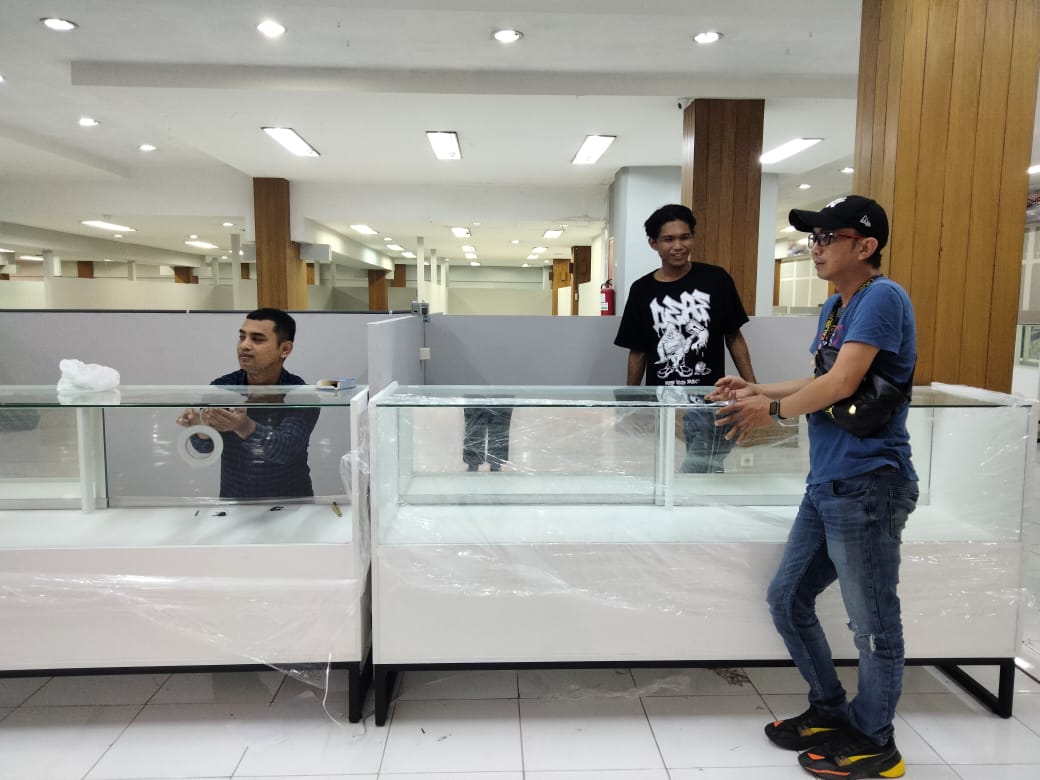MULAI BERJUALAN: Beberapa tenant yang terimbas kebakaran Malang Plaza melakukan pengecekan kondisi etalase di lantai dua Sarinah, kemarin (16/7).