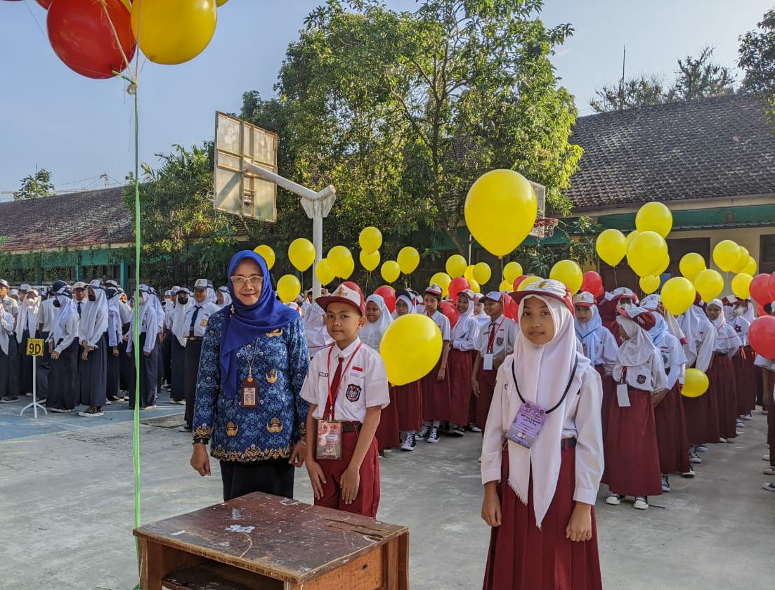 INOVATIF : Kepala SMPN 4 Malang Dr Pancayani Dinihari (kiri) bersama seluruh peserta MPLS sebelum pelepasan balon di halaman sekolah, kemarin (17/7).