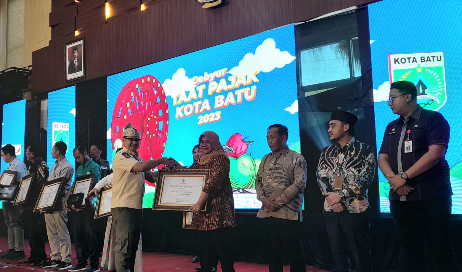 TAAT PAJAK: Pj Wali Kota Batu Aries Agung Paewai menyerahkan penghargaan kepada warga dan instansi yang taat pajak, Kamis (20/7)