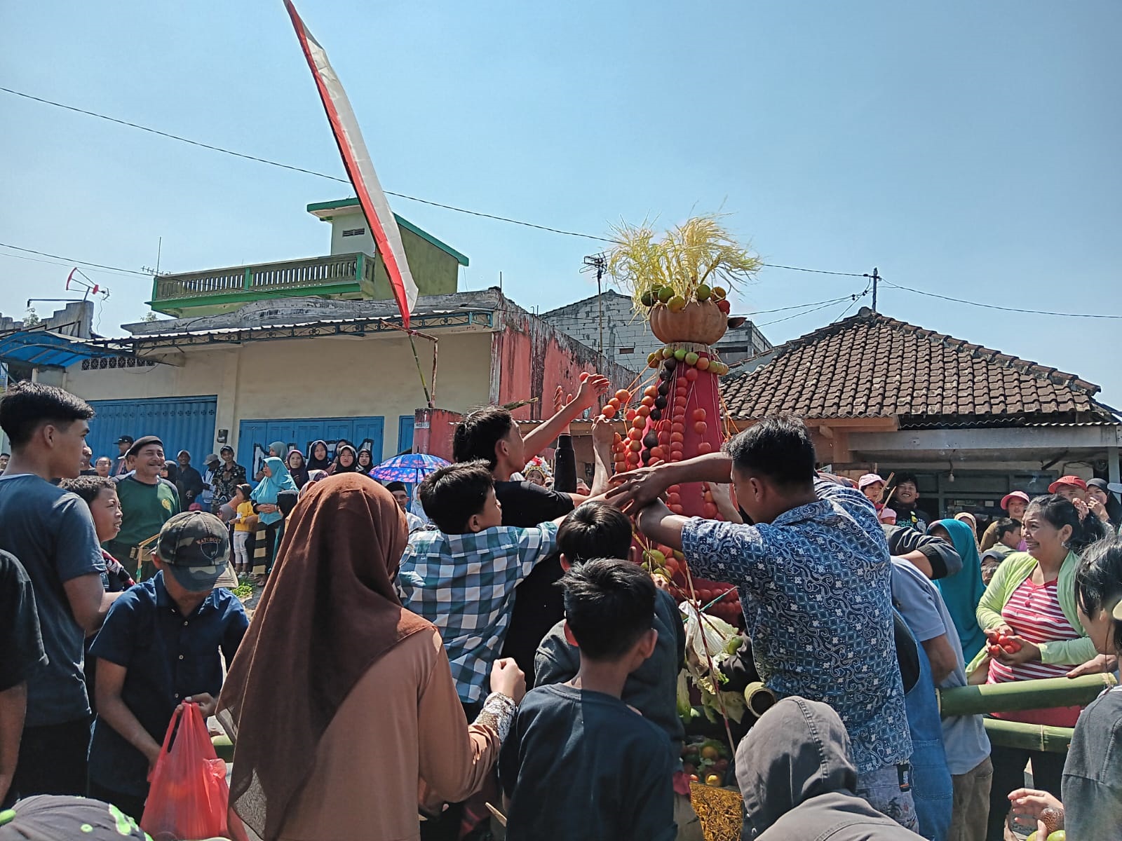 ASYIK REBUTAN: &nbsp;Warga saling berebut isi gunungan hasil panen setelah diarak di Dusun Ngujung, Desa Toyomarto, Kecamatan Singosari, kemarin (23/7). (Indah Mei Yunita/Radar Malang)  &nbsp;