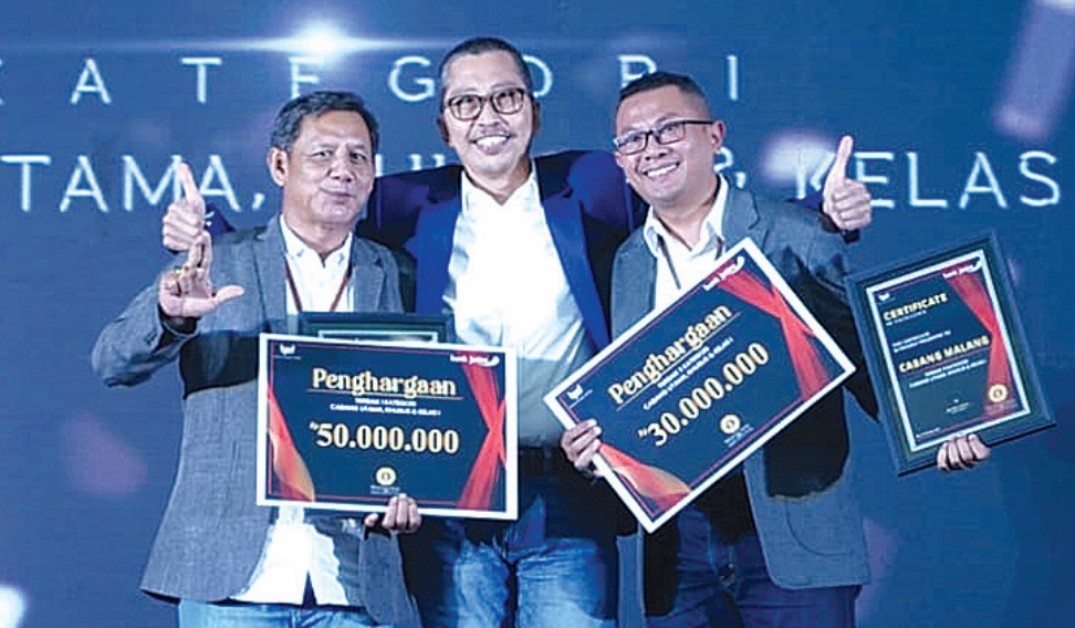 Pemimpin Bank Jatim Cabang Malang Deddy Adjie Wijaya (kanan) bersama Direktur Utama Bank Jatim Busrul Iman (tengah) menunjukkan sertifikat dan penghargaan terbaik dalam awarding night Bank Jatim.