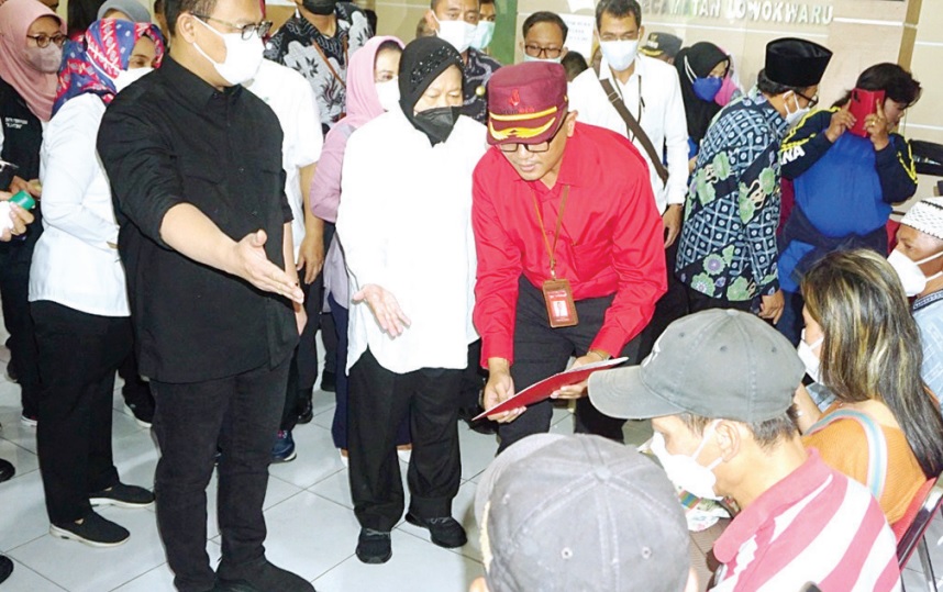 Pemimpin Bank Jatim Cabang Malang Deddy Adjie Wijaya (baju merah) mendampingi Menteri Sosial Tri Rismaharini (depan, dua dari kiri) saat memberikan santunan korban tragedi Kanjuruhan.