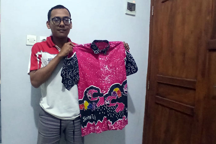 Khoirul Rizky, menunjukkan batik hasil karya Shining Tuli.