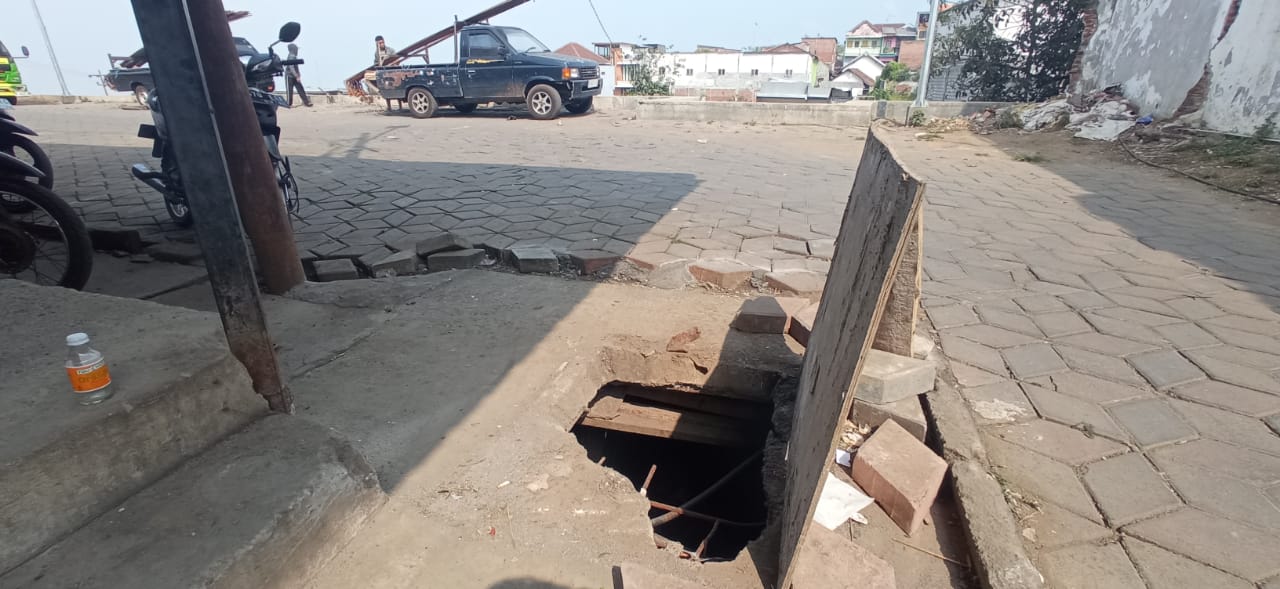 MEMBAHAYAKAN: Tutup drainase di belakang Pasar Sayur Kota Batu pecah dan menimbulkan lubang yang menganga.