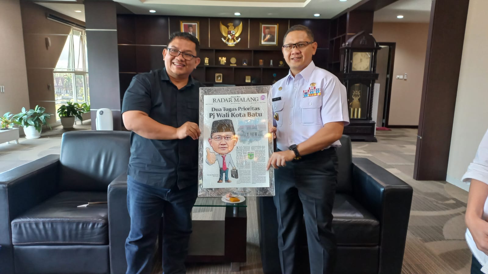 TUKAR PIKIRAN: Direktur Jawa Pos Radar Malang Tauhid Wijaya (kiri) menyerahkan kenang-kenangan kepada Pj Wali Kota Batu Aries Agung Paewai, Rabu (26/6).