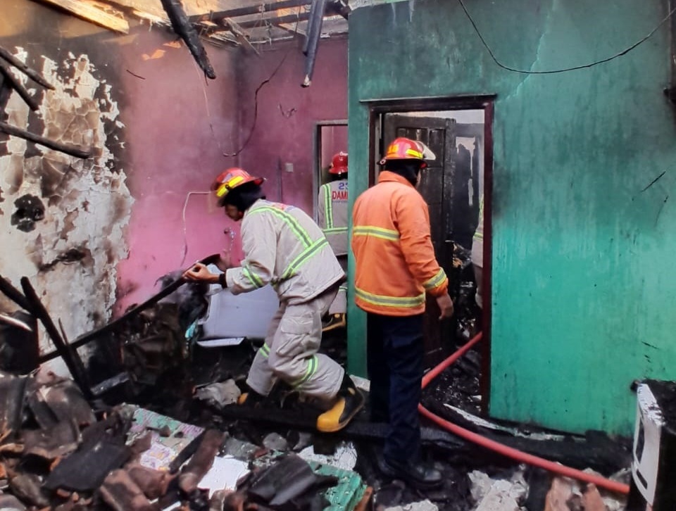 TINGGAL PUING: Petugas Damkar Kabupaten Malang memadamkan sisa api yang membakar rumah warga di Dusun Bugis, Desa Saptorenggo, Kecamatan Pakis.